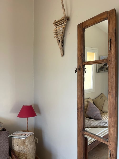 Miroir rustique en bois et lampe rouge dans la chambre de l'hôtel Vista D'oro, Monacia d'Aullène, avec décor côtier et reflet de chambre