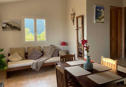Lumineux séjour à Vista D'oro avec vue mer, mobilier en bois et fleurs rouges à Monacia d'Aullène