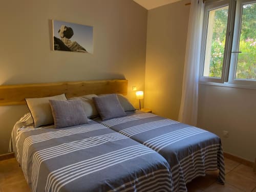 Chambre contemporaine à Vista D'oro à Monacia d'Aullène avec lits jumeaux, éclairage chaleureux et vue sur mer