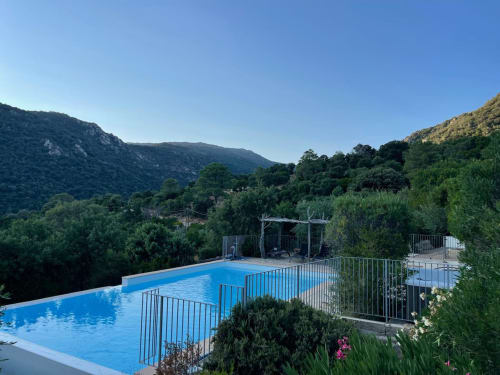Piscine de l'hôtel Vista D'oro dominant la vallée de Monacia d'Aullène avec montagnes et paysage méditerranéen