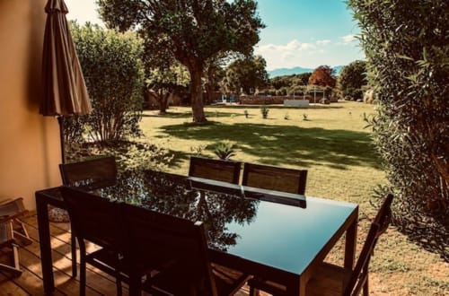 Terrasse de restaurant en plein air à Tamaricciu Di Cala Rossa avec vue sur le jardin, pelouses et arbres à Lecci