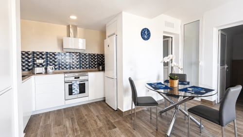 Cocina y comedor moderno en Apartamento Severo 2, La Aldea con azulejos azules, muebles blancos y vistas al mar