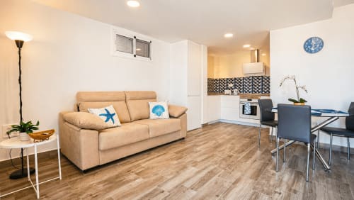 Apartamento diáfano y luminoso en La Aldea con sofá beige, zona de comedor, cocina equipada y decoración con vistas al mar