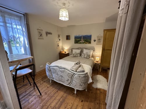 Cozy bedroom at Chambre d'Hôtes Les Iris with white bed, wooden desk, soft lighting, and garden view in Les Trois-épis
