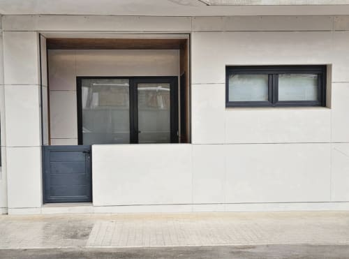 Fachada moderna del hotel BR Silgar en Sanxenxo con puertas de cristal, marcos oscuros y exterior minimalista de paneles blancos