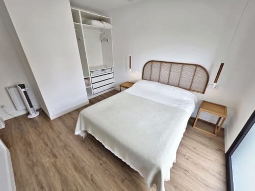 Dormitorio luminoso en BR SILGAR Sanxenxo con cama matrimonial, cabecero de madera, armario empotrado y suelo de madera.