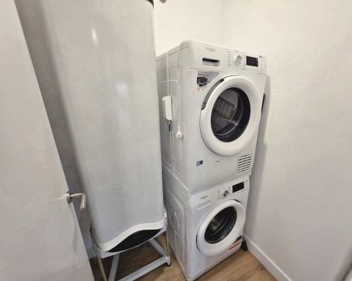 Lavadora y secadora apiladas con calentador de agua en la zona de lavadería del apartamento BR SILGAR, Sanxenxo