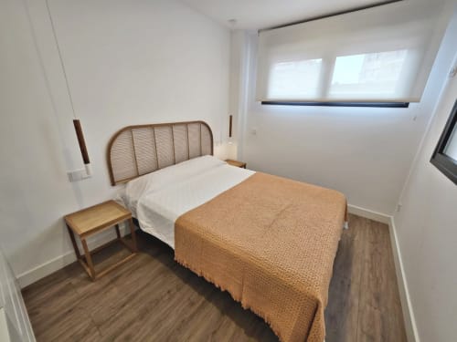 Luminoso dormitorio en apartamento BR SILGAR, Sanxenxo con cama de madera, ropa de cama blanca y suelo de madera