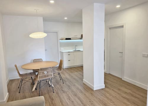 Comedor y cocina modernos en BR SILGAR Sanxenxo con mesa redonda, lámpara colgante y muebles blancos