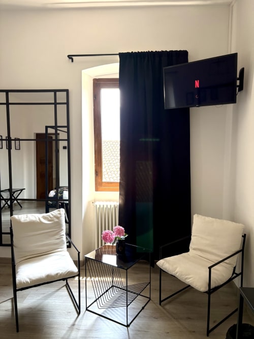 Camera moderna a La Dolce Casa a Cremia con letto a baldacchino nero, area relax e TV Netflix