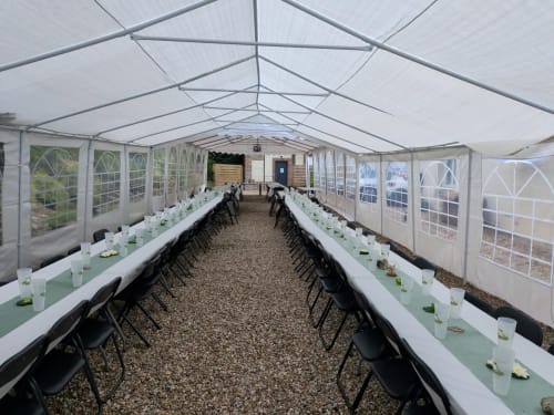 Elegant marquee dining setup at Les Gites De Flaubert with garden views, perfect for events