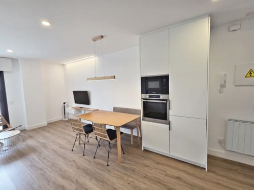 Cocina y comedor moderno en BR SILGAR Sanxenxo con muebles blancos y mesa de madera