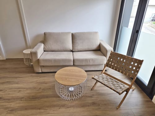 Moderno salón de apartamento en BR SILGAR Sanxenxo con sofá beige, mesa de café de madera y silla tejida