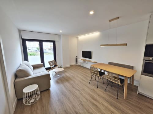 Moderno apartamento en BR SILGAR Sanxenxo con sala de estar abierta, comedor, zona de descanso cómoda, cocina y televisión