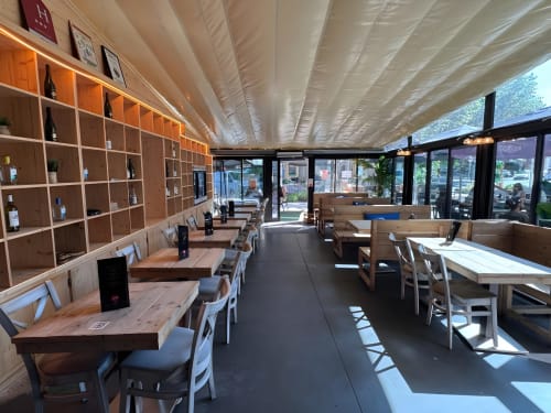 Modern restaurant interior at Hôtel de la Bourse with wooden shelving, dining tables, and large windows overlooking