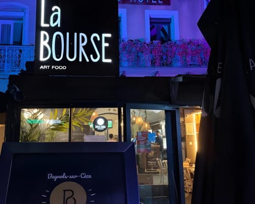La Bourse Art Food restaurant facade at Hôtel de la Bourse, Bagnols-sur-Cèze, lit with blue neon signage