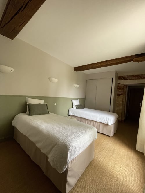 Chambre twin avec boiseries vertes, poutres apparentes et vue sur le jardin à la Maison Nolette, Noyelles sur Mer