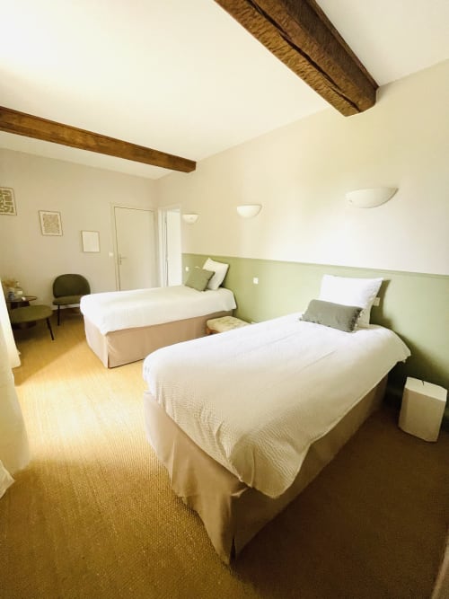 Lits jumeaux dans la Suite lumineuse de la Maison Nolette à Noyelles sur Mer, avec poutres en bois et vue sur le jardin