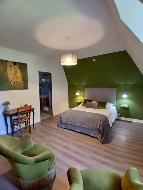 Chambre double moderne au Clos Gaillardou avec mur d'accent vert, luminaires suspendus et vue sur le jardin à La Roque-Gageac