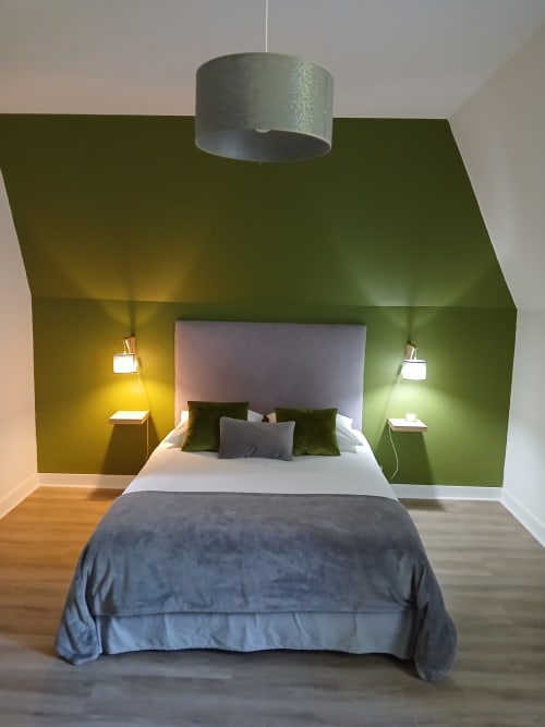 Chambre double moderne au Clos Gaillardou à La Roque-Gageac avec murs accent verts et luminaires suspendus