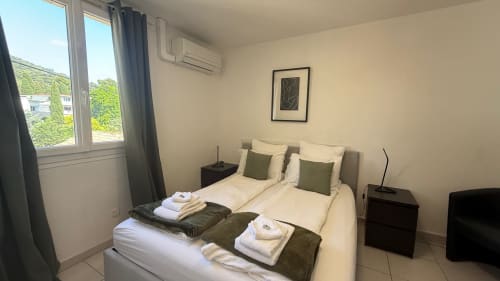 Chambre studio à la Kimi Résidence à Cannes avec lits jumeaux, vue sur jardin, climatisation et équipements modernes