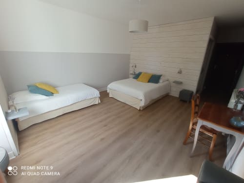 Chambre triple du gîte Le Clos Gaillardou à La Roque-Gageac avec deux lits et parquet