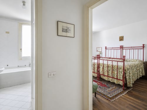 Camera Rossa di Palazzo Bonfiglioli con letto in metallo rosso, biancheria botanica e bagno ensuite a San Giovanni in Persiceto