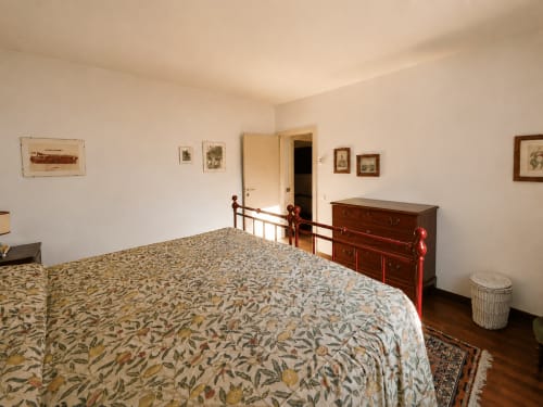 Stanza Rossa a Palazzo Bonfiglioli con copriletto decorativo, mobili in legno e quadri incorniciati