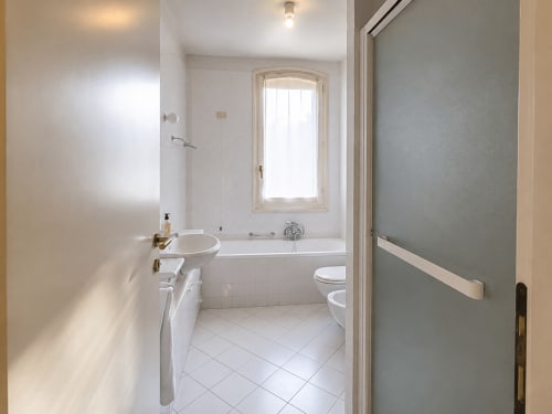 Bagno luminoso con piastrelle bianche, lavabo, vasca e WC a Palazzo Bonfiglioli, San Giovanni in Persiceto
