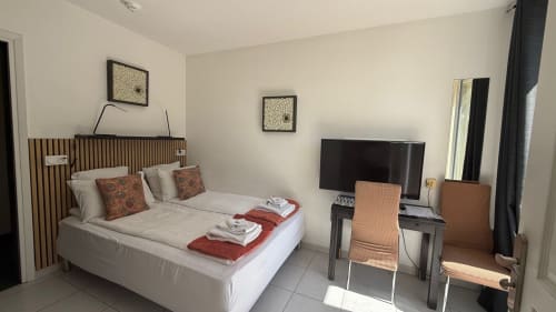 Appartement hôtel moderne à la Kimi Résidence à Cannes avec lit, bureau TV et accès balcon vue jardin