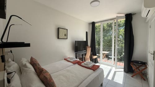 Chambre moderne à la Kimi Résidence à Cannes avec lit queen, balcon vue jardin, TV et kitchenette