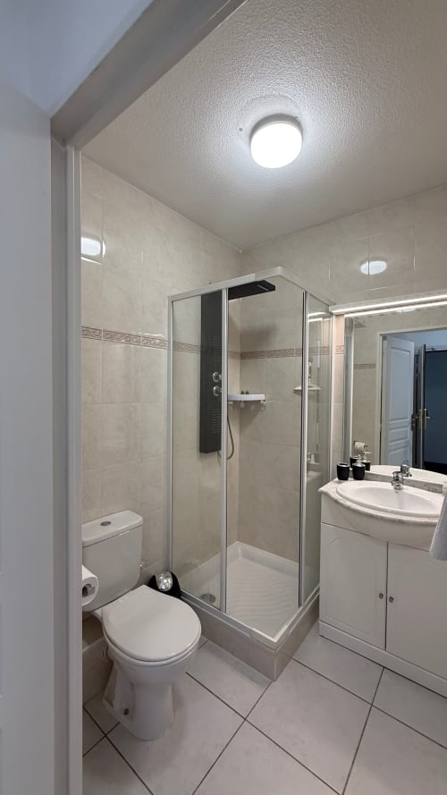 Salle de bain moderne à la Kimi Résidence à Cannes avec douche, toilettes et meuble-vasque