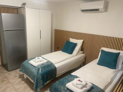 Studio avec deux lits simples et accents turquoise à Kimi Résidence à Cannes, kitchenette et climatisation