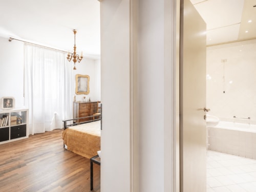Camera Rosa a Palazzo Bonfiglioli con pavimento in legno, mobili d'epoca, lampadario e bagno privato a San Giovanni in
