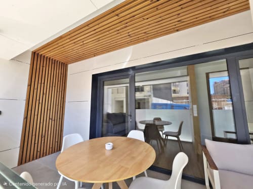 Sala Club BR Silgar en Sanxenxo con techo de madera, mesa redonda, sillas blancas y puertas acristaladas al salón