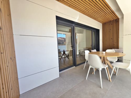 Sala del Club BR Silgar en Sanxenxo con mesa de comedor, sillas blancas, toques de madera y acceso a terraza