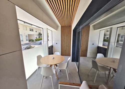 Zona de comedor del BR Silgar Club 3 en Sanxenxo con mesas de madera, sillas blancas y detalles modernos de techo de madera