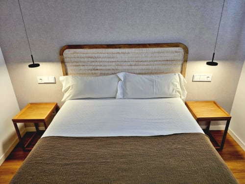 Dormitorio del BR Silgar Club en Sanxenxo con cabecero tejido moderno, ropa de cama blanca, mesitas de noche de madera e iluminación colgante