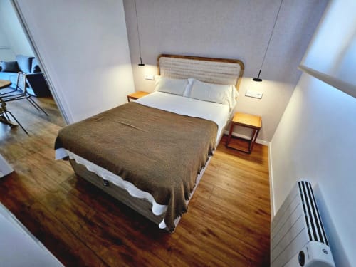 Moderno dormitorio en el hotel BR Silgar Club de Sanxenxo con cama de matrimonio, cabecero de madera, lámparas colgantes y pisos de madera noble