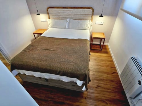 Moderno dormitorio del BR Silgar Club en Sanxenxo con cama queen, mesitas de noche de madera e iluminación colgante
