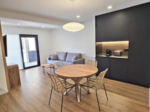 Espacio de planta abierta BR Silgar Club 3 con mesa de comedor, cocina, sofá e iluminación colgante en Sanxenxo