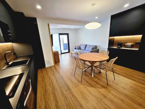 Área de comedor moderno en habitación 3 del BR Silgar Club, Sanxenxo con mesa de madera, mueblería negra y sala de estar