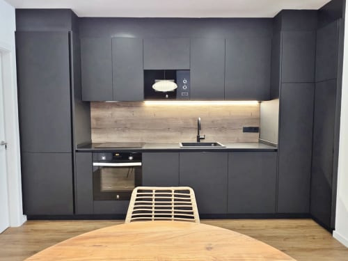 Cocina moderna en la habitación BR Silgar Club 3 del hotel Sanxenxo con muebles oscuros, backsplash de madera y zona de comedor
