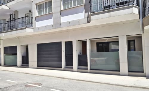 Escaparate de la planta baja del hotel BR Silgar en Sanxenxo con persianas negras modernas y puertas de cristal