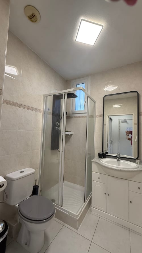 Salle de bains moderne de la Résidence Kimi à Cannes avec cabine de douche, lavabo et toilettes