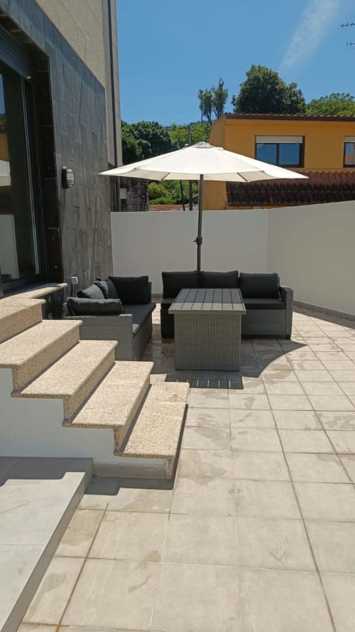 Patio moderno de Bahía Rental Baiona con zona de estar, sombrilla y terraza para comer