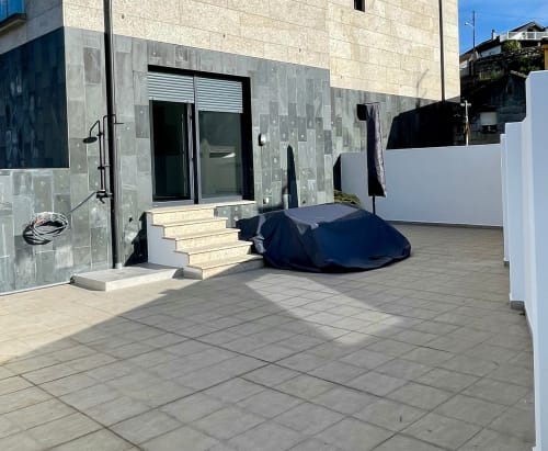 Terraza de apartamento en Baiona con patio de azulejos, barandillas blancas y garaje cubierto en Bahía Rental