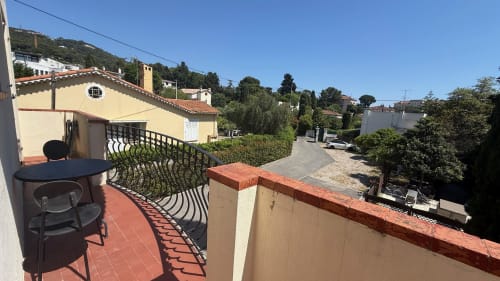 Balcon privé de la Résidence Kimi à Cannes avec carrelage en terre cuite, vue sur le jardin et architecture méditerranéenne