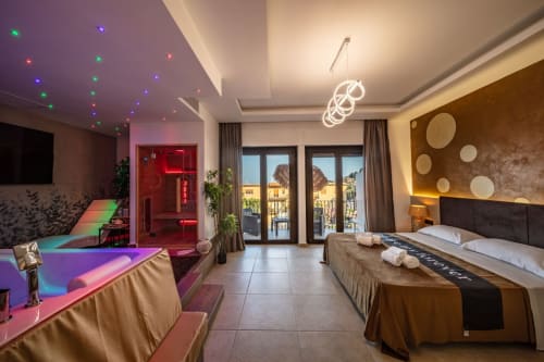 Luxurious Superior Suite in Taormina with sea views, modern neon lighting, king bed, full kitchen, and balcony overlooking