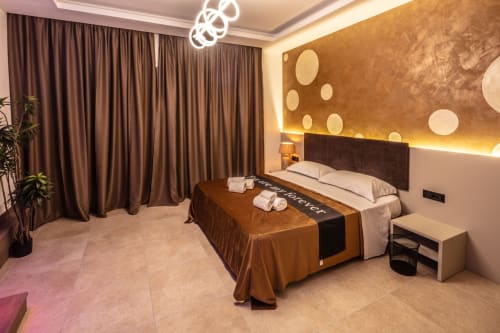 Luxury Superior Suite bedroom at Suite Apartment Taormina with golden accent wall, modern lighting, and contemporary